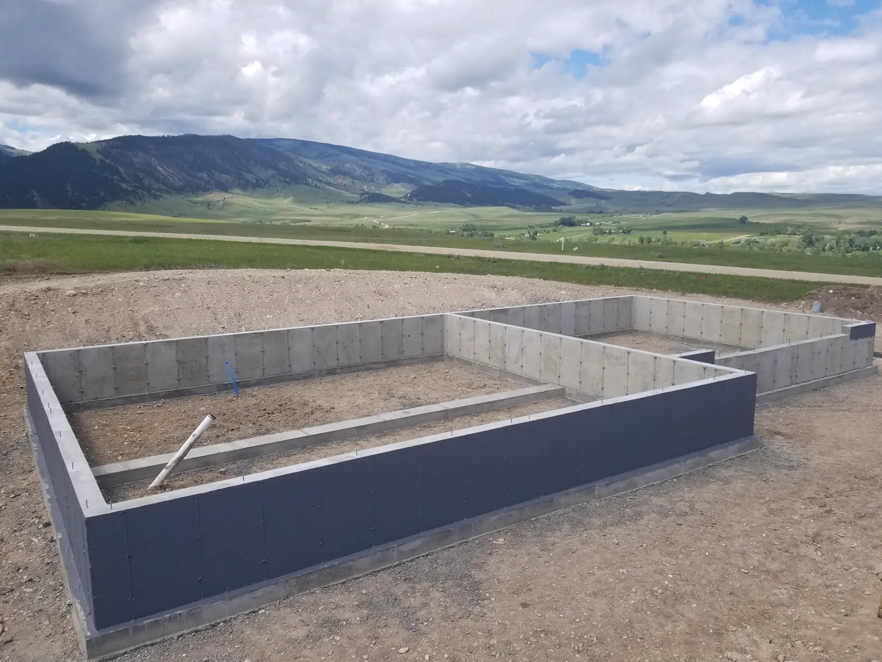 A new foundation with the mountains behind it, northern Wyoming