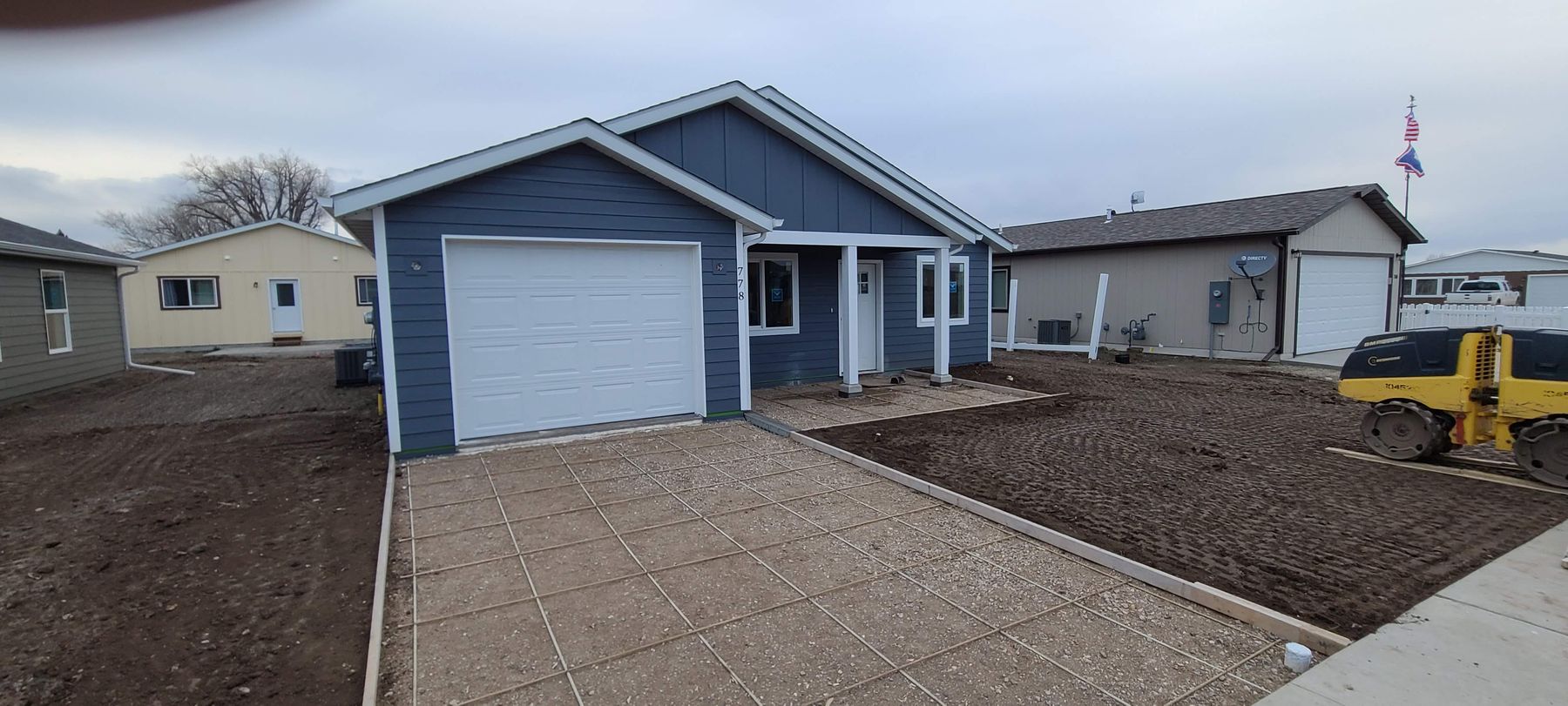 Blue home with garage and paver driveway built by Build It Brothers